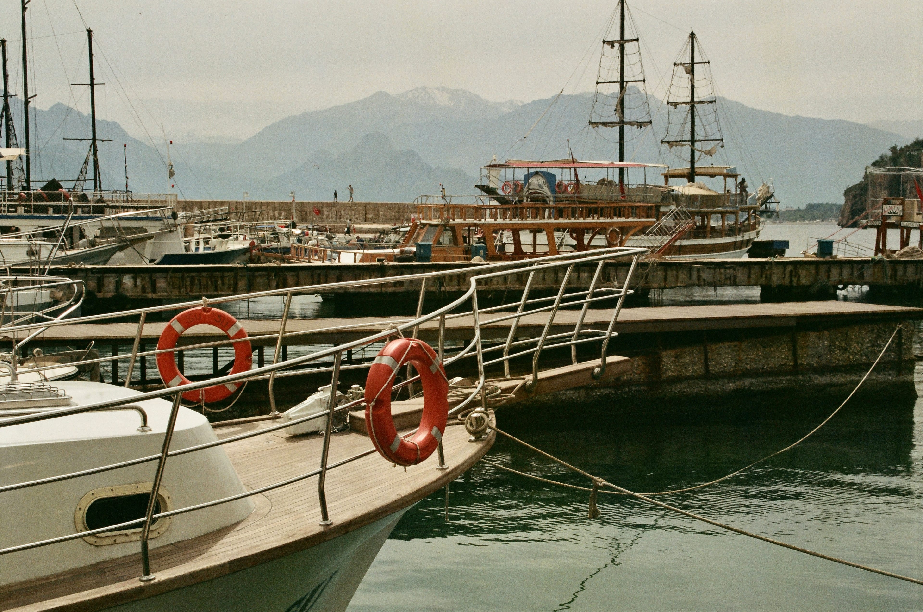 Boats moored at a marina with mountains