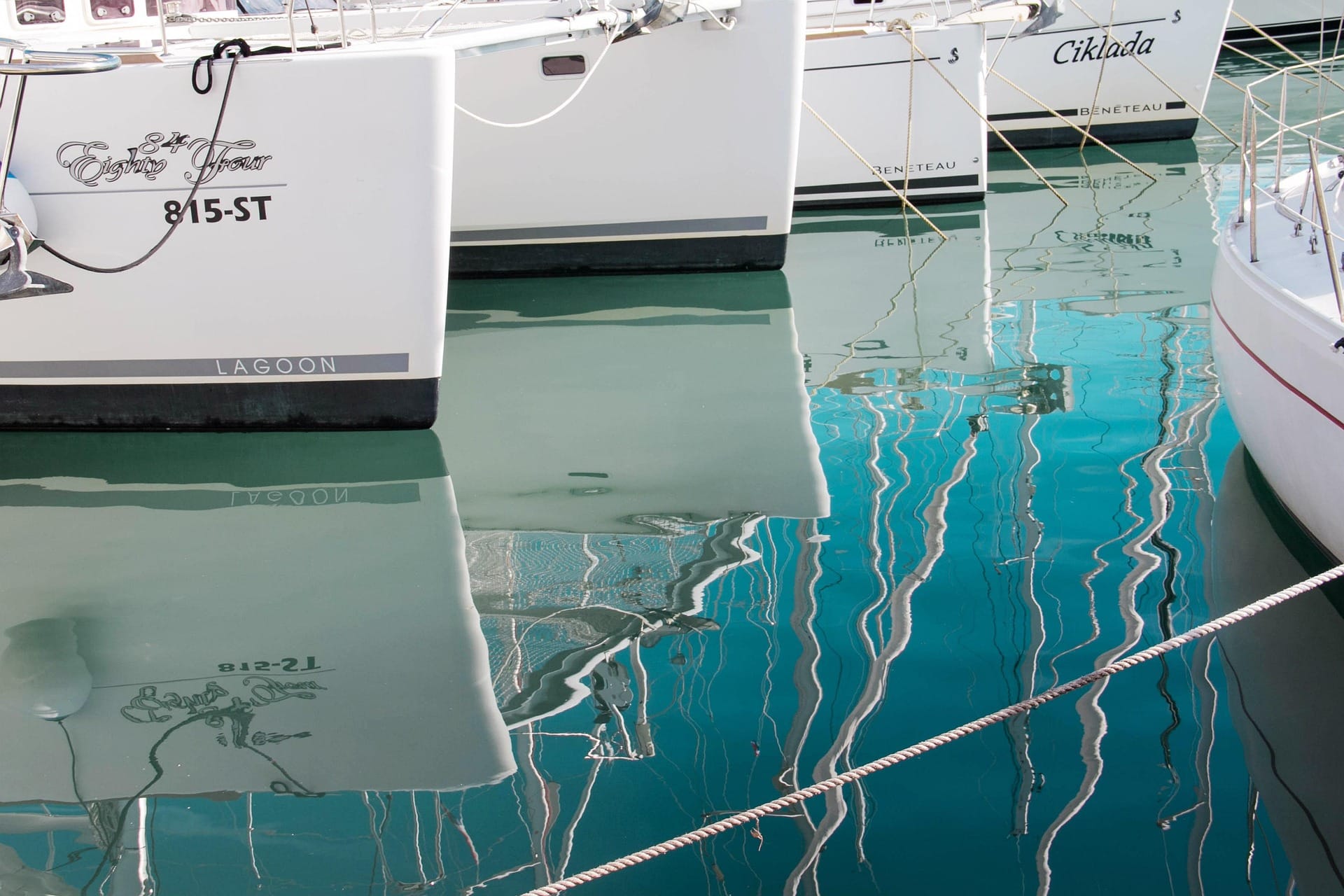 Sailboats reflected in calm marina water